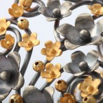 A close up of the metal flowers on the wall.