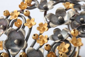 A close up of the metal flowers on the wall.