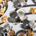 A close up of the metal flowers on the wall.