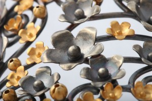 A close up of the metal flowers on the wall.