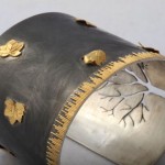 A close up of the metal and gold leaf design on the cuff.