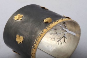 A close up of the metal and gold leaf design on the cuff.