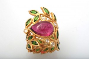 A gold ring with leaves and a pink stone.