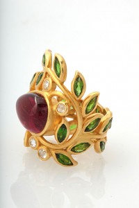 A gold ring with leaves and gemstones