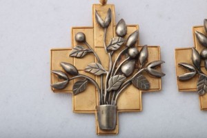 A gold and silver pendant with flowers in it.
