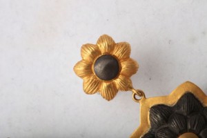 A close up of the top part of a gold earring