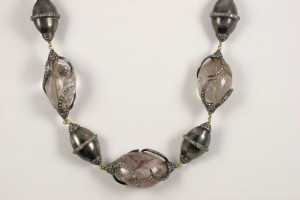 A necklace with silver and glass beads on it.