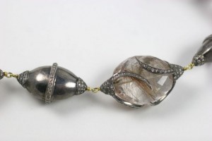 A necklace with two large balls and diamonds.