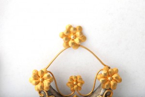 A yellow flower and metal ornament on the wall.