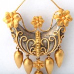 A gold and silver necklace with flowers hanging from the bottom.