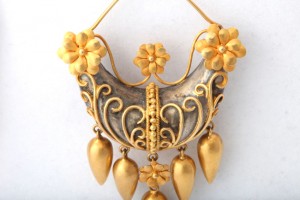 A gold and silver necklace with flowers hanging from the bottom.