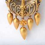 A close up of the gold earrings on a white background