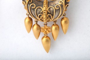 A close up of the gold earrings on a white background