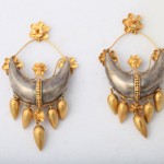 A pair of earrings with gold and silver details.