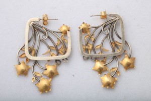 A pair of earrings with gold flowers hanging from the bottom.