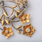 A close up of the flowers and leaves on a brooch