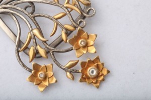 A close up of the flowers and leaves on a brooch