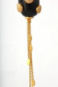 A gold chain hanging from the side of a black object.