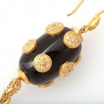 A black and gold necklace with a large bead.