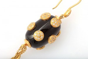 A black and gold necklace with a large bead.