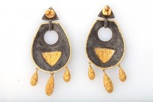 A pair of earrings with gold and black designs.