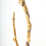 A pair of bamboo earrings with silver leaves.