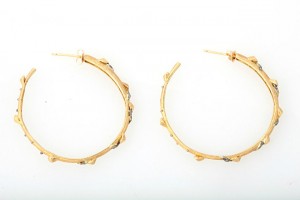 A pair of gold hoop earrings with blue stones.