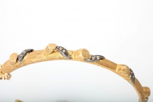 A close up of the side of a gold bracelet