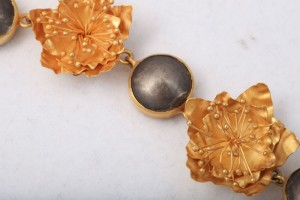 A close up of the gold and black necklace