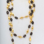 A long necklace with gold and black beads.