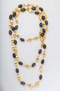 A long necklace with gold and black beads.