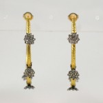 A pair of gold and diamond earrings.