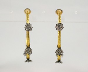 A pair of gold and diamond earrings.
