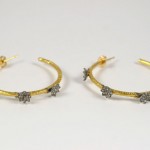 A pair of gold and diamond hoop earrings.