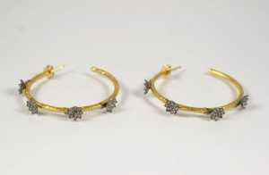 A pair of gold and diamond hoop earrings.