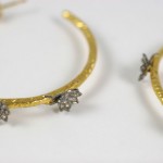 A pair of gold and diamond earrings with three stars.