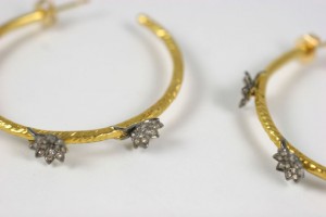 A pair of gold and diamond earrings with three stars.