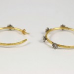 A pair of gold and diamond hoop earrings.