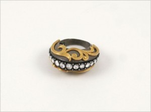 A gold and silver ring with pearls on top of it.