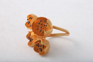 A gold ring with three flowers on it.