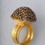 A gold ring with a diamond shaped stone on top of it.