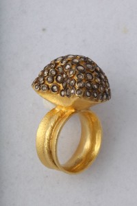 A gold ring with a diamond shaped stone on top of it.
