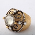 A gold ring with some white stones on it