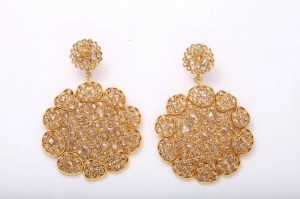 A pair of gold earrings with large, round diamonds.