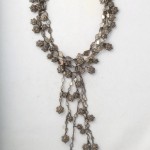 A long necklace with silver beads and chains.