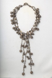 A long necklace with silver beads and chains.
