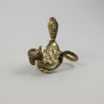 A gold snake ring with diamonds on top of it.