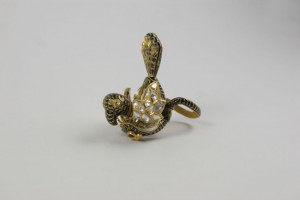 A gold snake ring with diamonds on top of it.