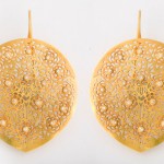 A pair of gold earrings with intricate designs.