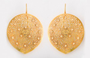 A pair of gold earrings with intricate designs.